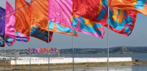 Jubilee Swimming Pool and Flags, with St Michaels Mount seen from the Western Promenade Penzance Cornwall UK